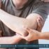 Man holding his right arm in pain, indicating possible nerve or muscular issues