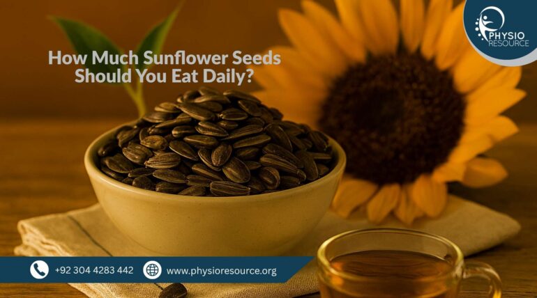 A ceramic bowl filled with sunflower seeds sits on a beige linen cloth atop a wooden surface. A halved sunflower and a glass cup of herbal tea are visible in the background. Image for Physio Resource.