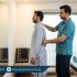 Physiotherapist guiding a patient in a clinic to correct standing posture for lower back comfort during long standing in prayer (Qiyam)