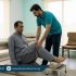 Physiotherapist guiding a patient in a clinic through safe knee flex mobility exercises to improve comfort for sujood and kneeling