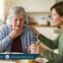 Elderly person coughing while eating with caregiver support, showing swallowing difficulty and choking risk – PhysioResource