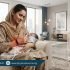Pakistani mother in modest clothing holding her baby while experiencing wrist pain at home – Physio Resource