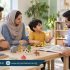 Young boy talking with a male speech therapist using toys and a picture book while both parents listen.